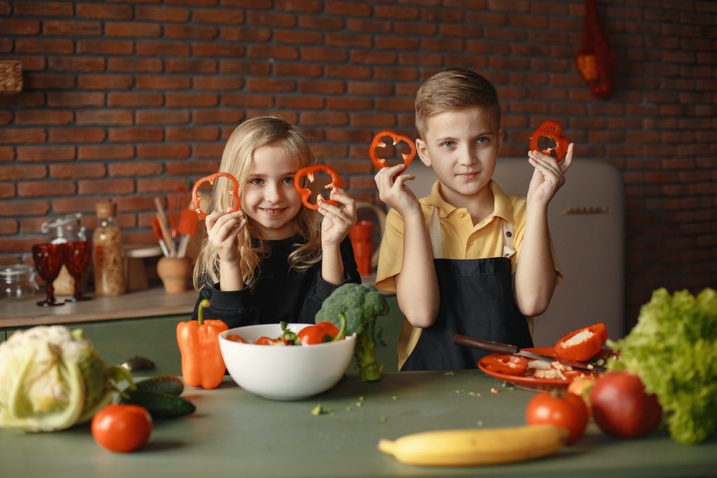 two kids chopping vegetables