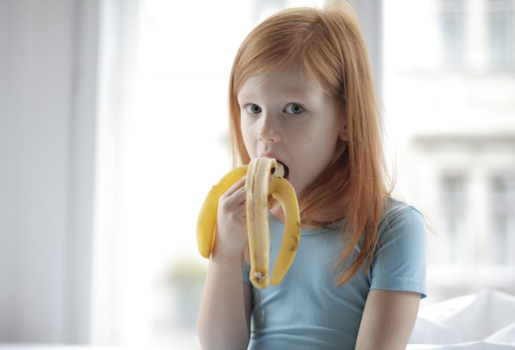 little girl eating a banana