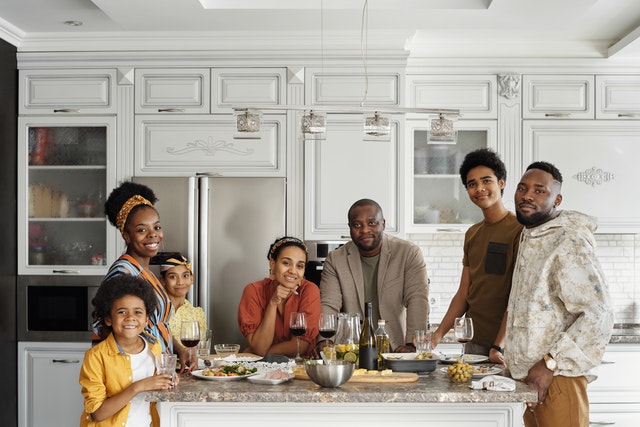 Family standing at the kitchen island with a meal